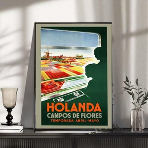 Może przedstawiać: Vintage plakat podróżniczy przedstawiający kolorowe pole tulipanów w Holandii, z wiatrakiem i błękitnym niebem. Plakat zawiera tekst "HOLANDA CAMPOS DE FLORES TEMPORADA ABRIL-MAYO" w kolorze pomarańczowym i białym. Sylwetki ludzi na pierwszym planie.