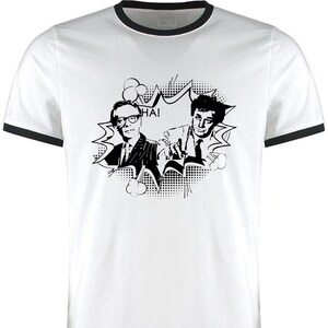 May include: A white t-shirt with a black and white comic book style image of two men laughing. The image includes the word "HA!" in a speech bubble.