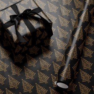 K&ouml;nnte beinhalten: Schwarzes Geschenkpapier mit einem goldenen, sich wiederholenden Muster aus stilisierten Weihnachtsb&auml;umen. Eine schwarze Geschenkbox mit einem schwarzen Band liegt auf dem Geschenkpapier. Eine Rolle Geschenkpapier ist teilweise abgewickelt.