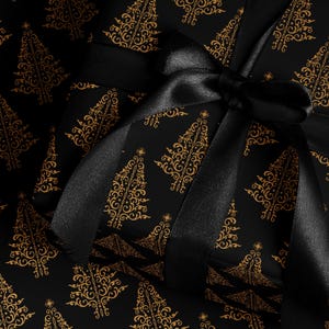 K&ouml;nnte beinhalten: Schwarzes Geschenkpapier mit einem goldenen Muster aus stilisierten Weihnachtsb&auml;umen. Ein schwarzes Satinband ist um das Geschenk gebunden.