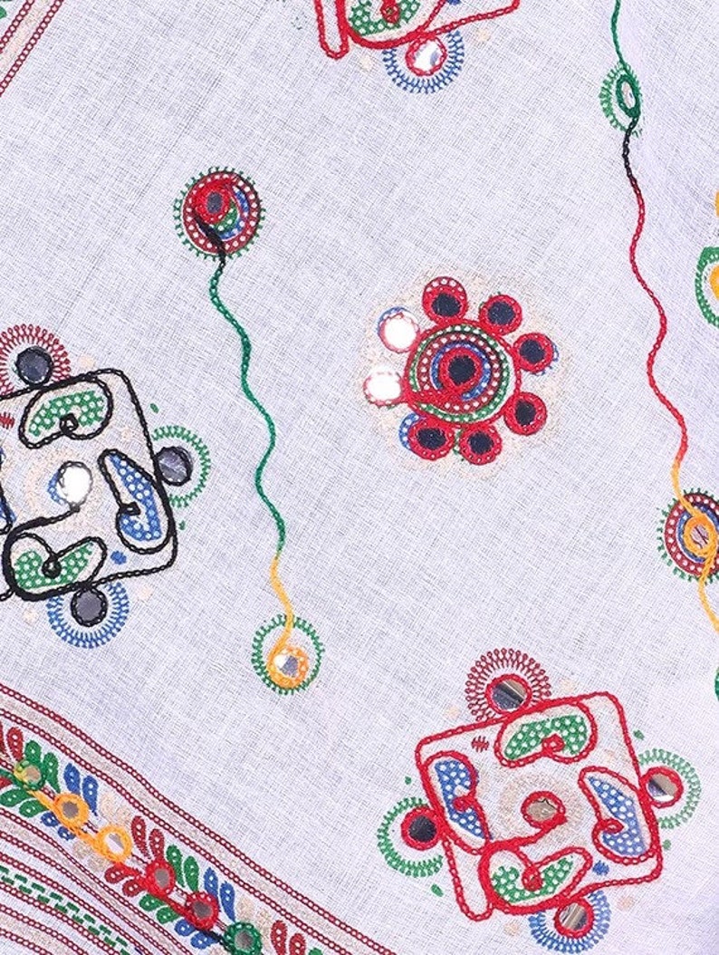 May include: White fabric with colorful embroidery and small round mirrors. The embroidery features geometric shapes and floral designs.