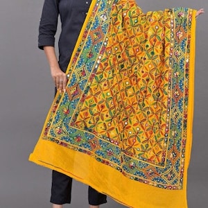 May include: A yellow dupatta with a colourful embroidered design and mirror work. The dupatta has a geometric pattern with floral motifs and a blue and green border.
