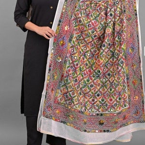 May include: A white dupatta with colourful embroidery and mirror work. The dupatta has a geometric pattern with floral motifs. The dupatta is paired with a black kurta and trousers.
