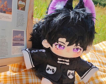 May include: A plush toy with black hair, purple cat ears, and a black and white panda print on the front of the jacket. The toy is wearing a black jacket with white trim and white shoes.