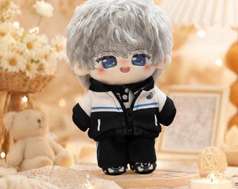 May include: A plush doll with a stylized anime appearance. The doll has gray hair, blue eyes, and rosy cheeks. It wears a black and white jacket with blue accents, black pants, and black shoes. The doll is a collectible item.