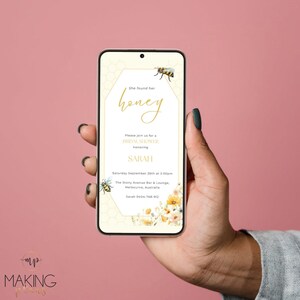 May include: A smartphone displays a bridal shower invitation with a bee and honeycomb design. The invitation reads "She found her honey" and includes details for Sarah's shower on September 26th at 2:00 pm in Melbourne, Australia.