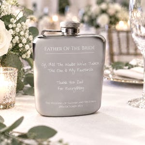 May include: A silver-toned metal flask with a screw-top lid, engraved with the text: FATHER OF THE BRIDE, Of All The Walks We've Taken This One Is My Favourite, Thank You Dad For Everything, THE WEDDING OF NATHAN AND VICTORIA, 29TH OCTOBER 2022.