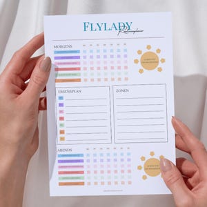 Può includere: Un planner di routine Flylady stampabile con sezioni per la mattina, la sera, la pianificazione dei pasti e le zone. Il planner presenta una griglia colorata con colori pastello e un'icona del sole.