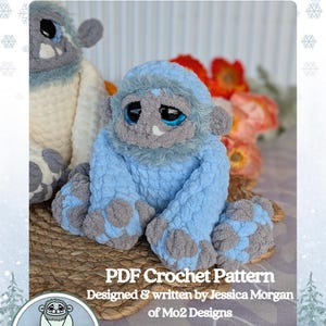 May include: A blue and gray crochet yeti plushie with the text "Arki Jr." and "PDF Crochet Pattern". The plushie has large eyes and is sitting on a woven surface. The design is by Jessica Morgan of Mo2 Designs.