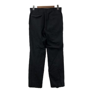 May include: Black dress pants hanging on a wooden hanger. The pants have a straight leg design and a single back pocket. The fabric appears to be a solid, dark color, suitable for formal or business attire.