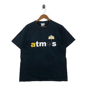 May include: Black t-shirt with the word "atmos" in yellow and white, and a cartoon bee graphic. The t-shirt is hanging on a wooden hanger.