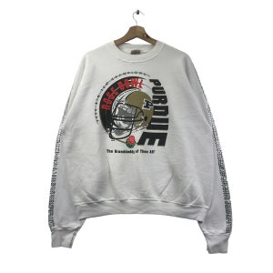 May include: White sweatshirt with a black and gold Purdue University logo and the text "Rose Bowl Champions" and "The Granddaddy of Them All". The sleeves have a silver glitter design.