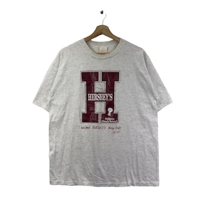 May include: Gray t-shirt with a maroon "H" for Hershey's and the text "I helped Hershey's help kids!" with the Children's Miracle Network logo.