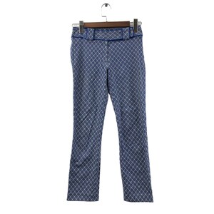 Op de afbeelding: Blauwe broek met een wit en blauw geometrisch patroon. De broek heeft een blauwe bies rond de tailleband en zakken.