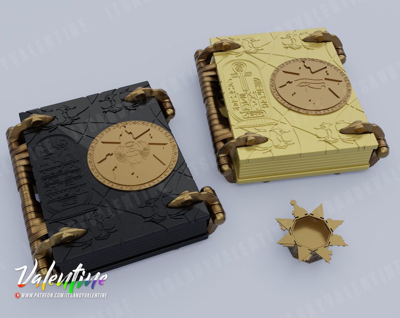 May include: Two closed books with gold and black covers and intricate designs. The books have a raised, circular design on the front cover. A small, gold, star-shaped object is in the foreground.