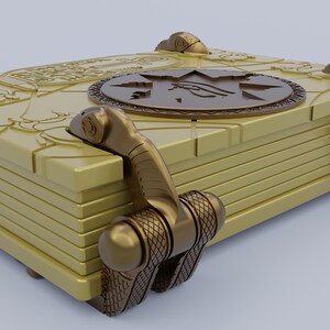 May include: A gold-colored book with intricate details and a circular design on the cover. The book has a series of clasps that are secured with a decorative metal hinge.