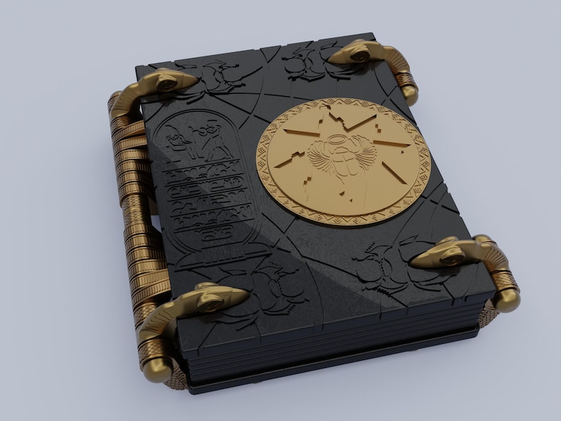 May include: A black book with gold accents and a circular design featuring an Egyptian scarab beetle. The book has a textured cover and multiple clasps.