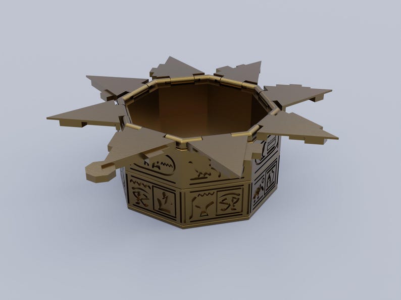 May include: A gold-colored, star-shaped, decorative box with a hexagonal base. The box is open and has intricate designs on the sides.