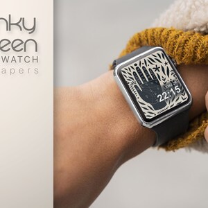 Puede incluir: Un smartwatch con una banda negra y una esfera blanca con un dise&ntilde;o de mano negra. La hora se muestra como 22:15, junto con el texto "THU 29".