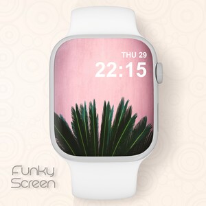 May include: A white Apple Watch with a pink background and a green palm tree on the screen. The time is 22:15 and the date is THU 29.