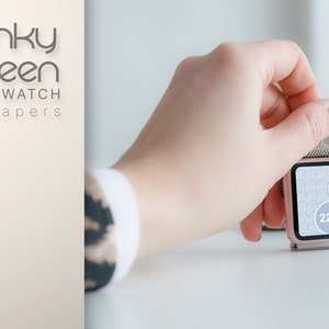 May include: A rose gold smartwatch with a white and gray geometric pattern on the screen. The time is 22:15.