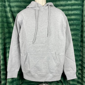May include: A grey hooded sweatshirt with a front pocket. The sweatshirt has a drawstring hood.