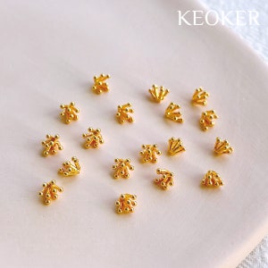 May include: A collection of 15 gold-toned metal bead caps with a starburst design. The bead caps are arranged on a white surface.