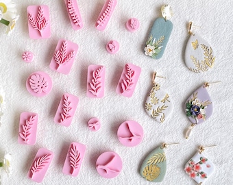 May include: A collection of pink polymer clay stamps featuring various leaf and branch designs, along with a set of handmade polymer clay earrings with floral and leaf patterns.
