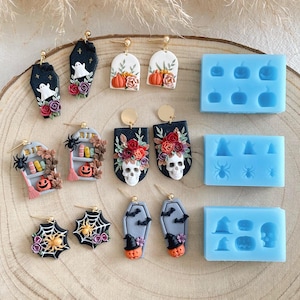 May include: A set of Halloween-themed earrings featuring various designs, including a coffin, a skull, a spiderweb, a bookshelf, and a pumpkin. The earrings are made from polymer clay and have gold ear wires. The image also shows silicone moulds for making the earrings.