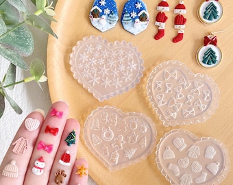 May include: A set of clear silicone molds in the shape of hearts, snowflakes, bows, and mittens. The molds are used for making resin jewelry or other crafts.