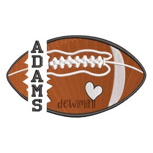 Puede incluir: Un balón de fútbol marrón y blanco con la palabra "ADAMS" cosida en el lateral. Un corazón blanco está cosido en el balón.