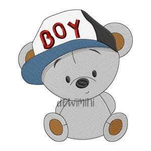 May include: A gray teddy bear wearing a blue and white baseball cap with the word "BOY" embroidered in red on the front. The bear is sitting with its paws in front of it.