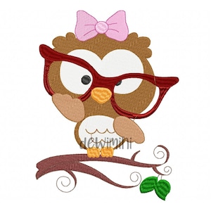 May include: A brown owl wearing red glasses and a pink bow, perched on a brown branch with green leaves.