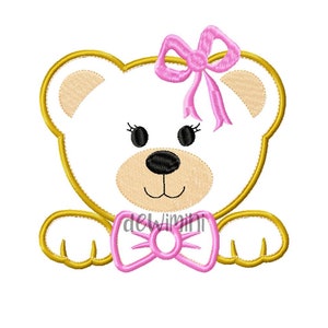 May include: Embroidered design of a white bear with a pink bow on its head and a pink bow tie. The bear has black eyes and a black nose. The bear is outlined in gold.
