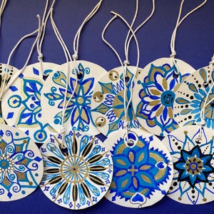 Set van 10 handgeschilderde blauwe geometrische mandala-patronen rond cadeaukaartjes.