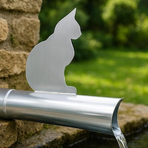 Könnte beinhalten: Eine silberfarbene Metall-Regenrinnenverlängerung mit einem flachen, silhouettenartigen Ausschnitt einer sitzenden Katze, die oben angeschweißt ist. Das zylindrische Rohr ist horizontal positioniert und lässt Wasser aus dem offenen Ende fließen.