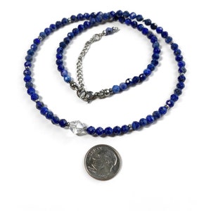 May include: A blue lapis lazuli beaded necklace with a clear crystal pendant. The necklace is approximately 18 inches long and is made with high-quality materials.