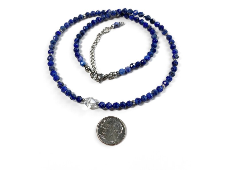 May include: A blue lapis lazuli beaded necklace with a clear crystal pendant. The necklace is approximately 18 inches long and is made with high-quality materials.