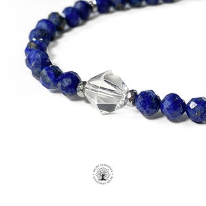 May include: A blue lapis lazuli gemstone bracelet with a clear crystal bead in the center.