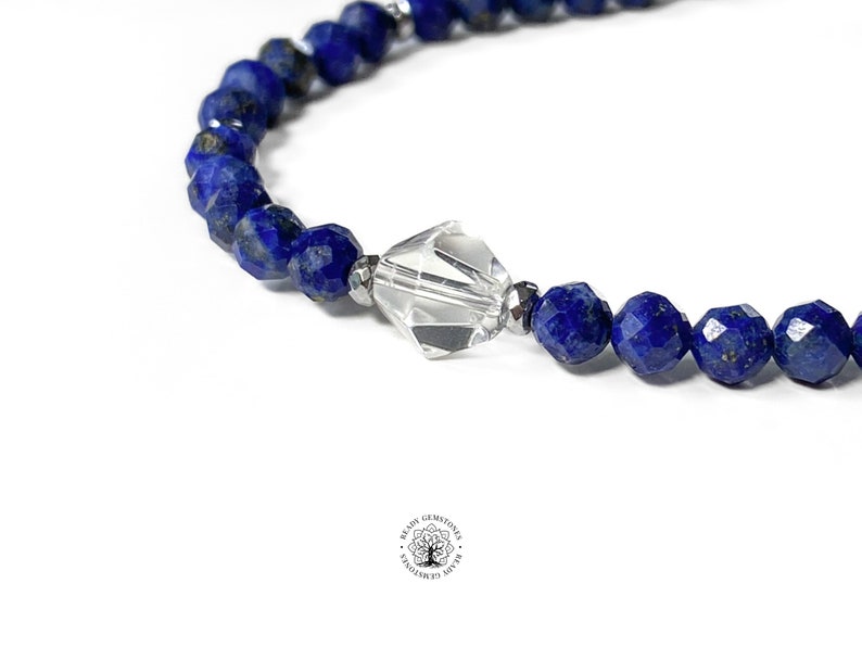 May include: A blue lapis lazuli gemstone bracelet with a clear crystal bead in the center.