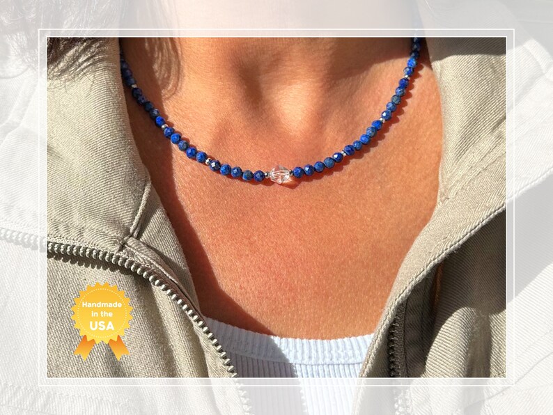 May include: A delicate necklace made with small blue lapis lazuli beads and a clear crystal pendant. The necklace is handmade in the USA.