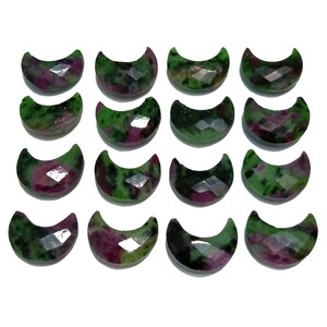 May include: A collection of 15 green and pink crescent moon shaped gemstones. The gemstones are faceted and have a mottled appearance.