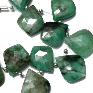 Può includere: Una collana di perle di pietra preziosa verde smeraldo con forma a goccia sfaccettata. Le perle sono infilate su un filo d'argento.
