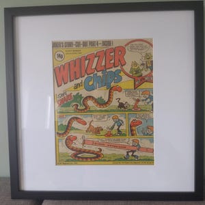 May include: A vintage comic book cover featuring a cartoon snake with the title "Whizzer and Chips" and the text "Joker's Story - Cut-Out Part 4 - Inside!" The comic book cover is framed in black.