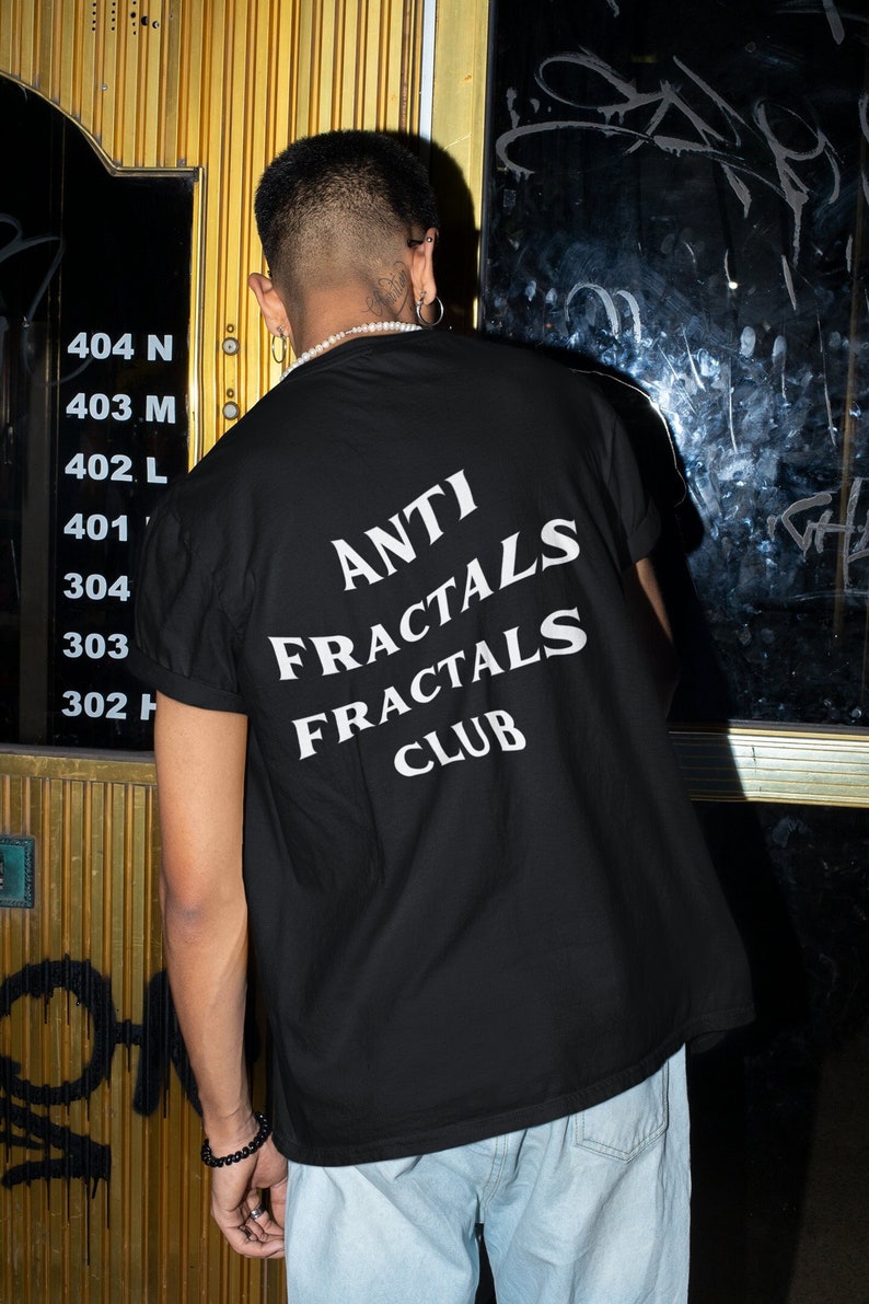 May include: A person wearing a black t-shirt with white text that reads "ANTI FRACTALS FRACTALS CLUB".