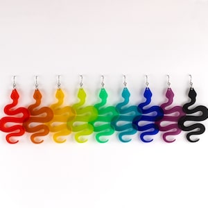 May include: A set of eight colorful snake-shaped earrings. The earrings are made of acrylic and are available in a variety of colors, including red, orange, yellow, green, blue, purple, and black.