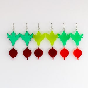 May include: A set of six earrings featuring a beet design. The earrings are made of acrylic and come in three colors: green, yellow, and red.