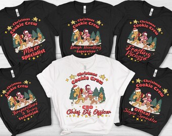 May include: A collection of black and white t-shirts with a Christmas theme. Each shirt features a graphic of gingerbread people and text that reads "Christmas Cookie Crew" with different job titles like "Mixer Specialist" and "Chief Elf Officer".