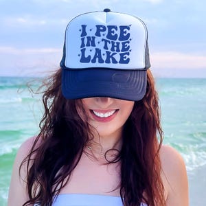 a woman wearing a hat that says i pee in the lake