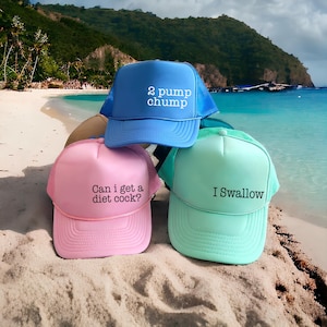 Puede incluir: Tres gorras tipo camionero con parte trasera de malla. La gorra azul tiene el texto blanco 2 pump chump. La rosa tiene el texto negro Can i get a diet cock? La verde menta tiene el texto negro I Swallow. Todas tienen la parte frontal de espuma.